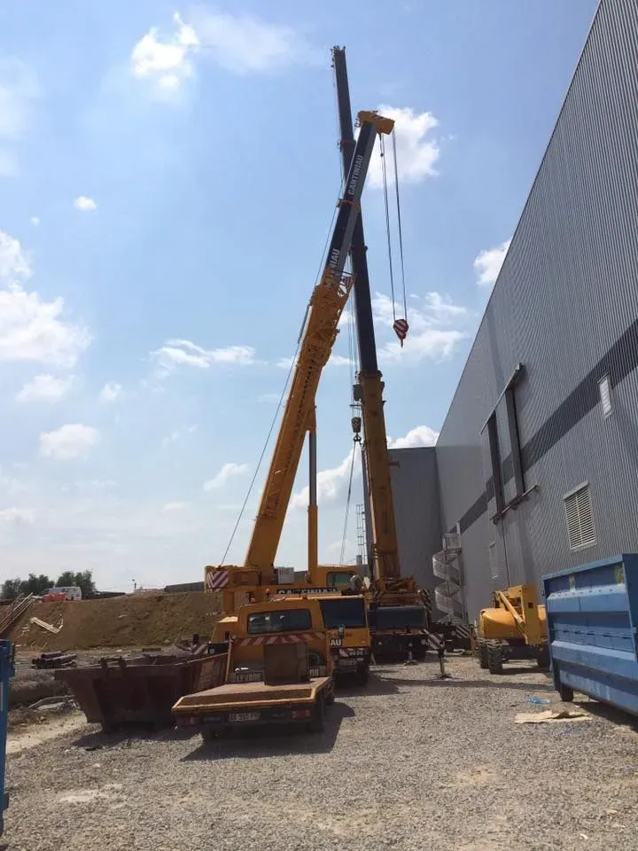 Deux grues positionnées le long d’un bâtiment