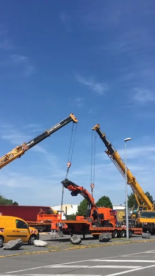 Deux grues autour d’un équipement sur remorque