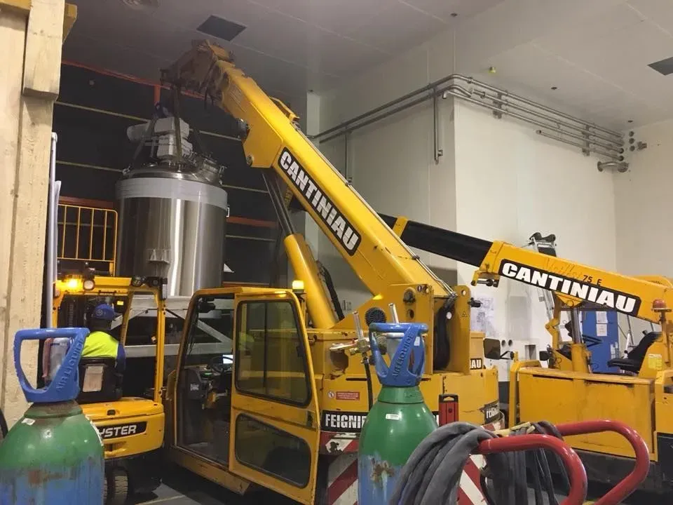 Plusieurs appareils de manutention Cantiniau autour d’une cuve dans un local industriel