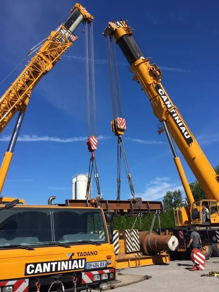 Deux grues pour la manutention d’une pièce industrielle