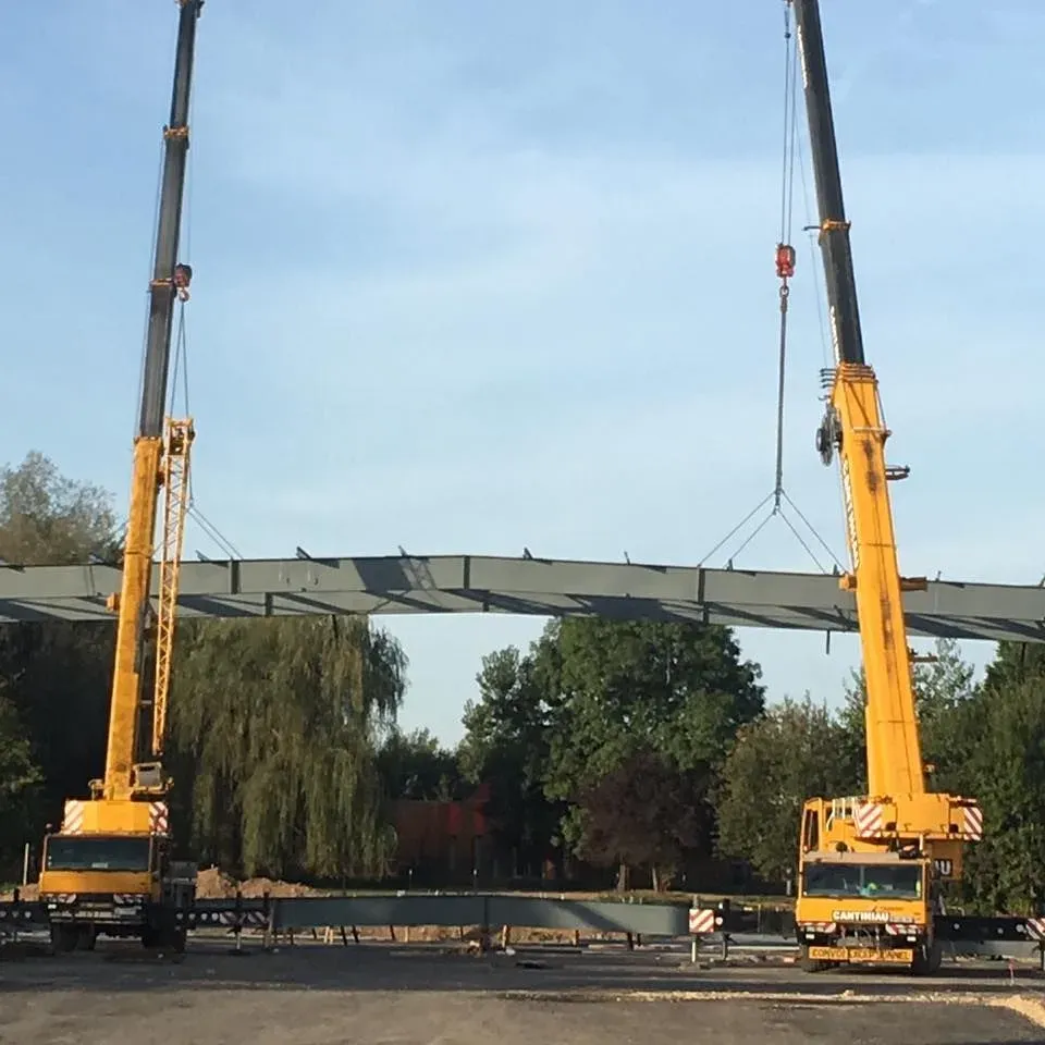 Deux grues Cantiniau soulèvent une longue structure métallique
